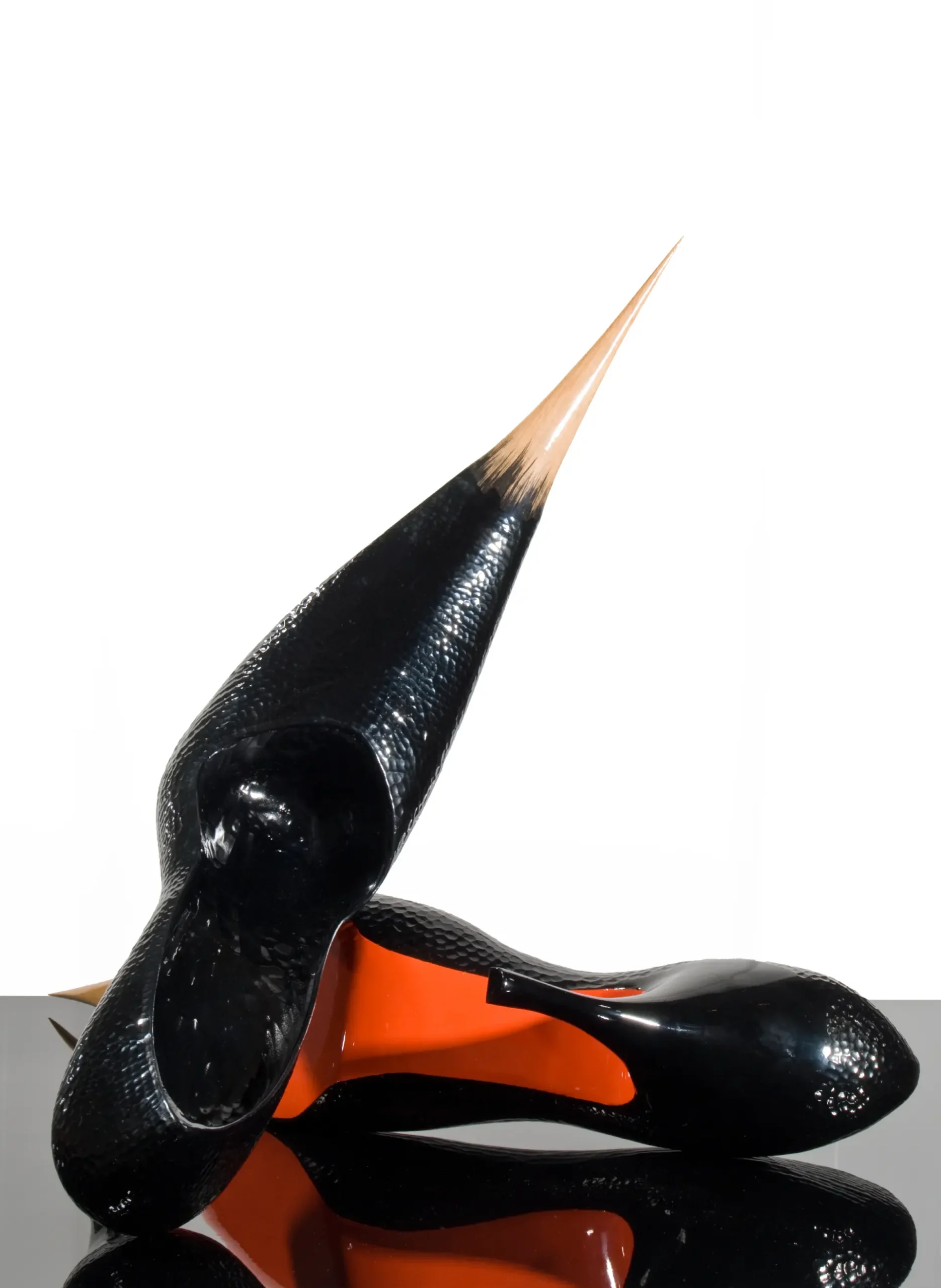 Sculptural black high-heeled shoes with elongated pointed heels and orange soles